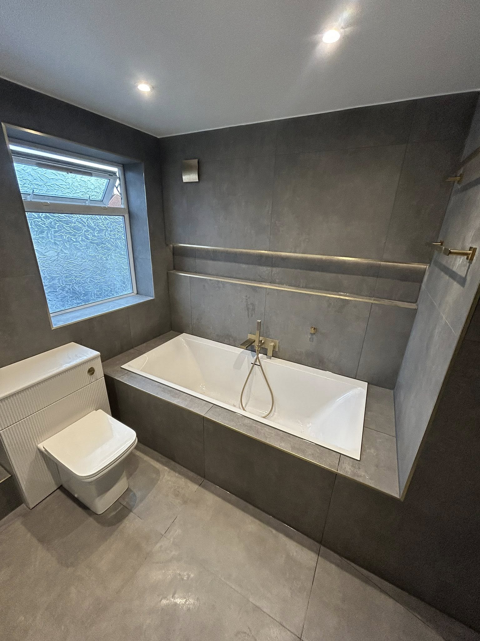 Cloakroom with fluted black vanity and slate tile